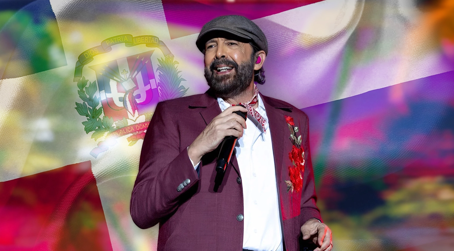 Cantante dominicano actuando con micrófono en mano, frente a una bandera de República Dominicana iluminada con luces de colores.
