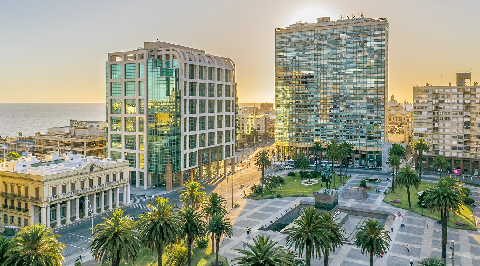 Vista aérea de una plaza moderna rodeada de edificios en una ciudad latinoamericana al atardecer.