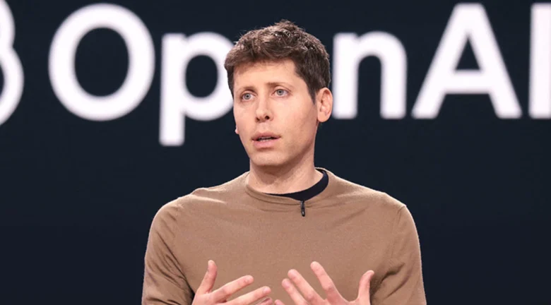 Persona hablando en una conferencia con el logo de OpenAI proyectado detrás.