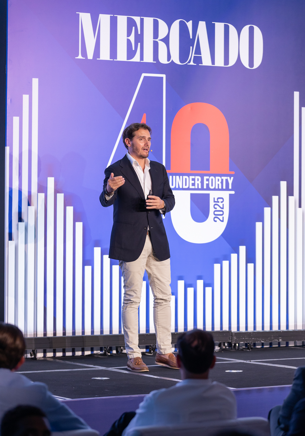 Albert Rivera. Exposición en un escenario azul con el logotipo de la marca Mercado y 40 Under 40