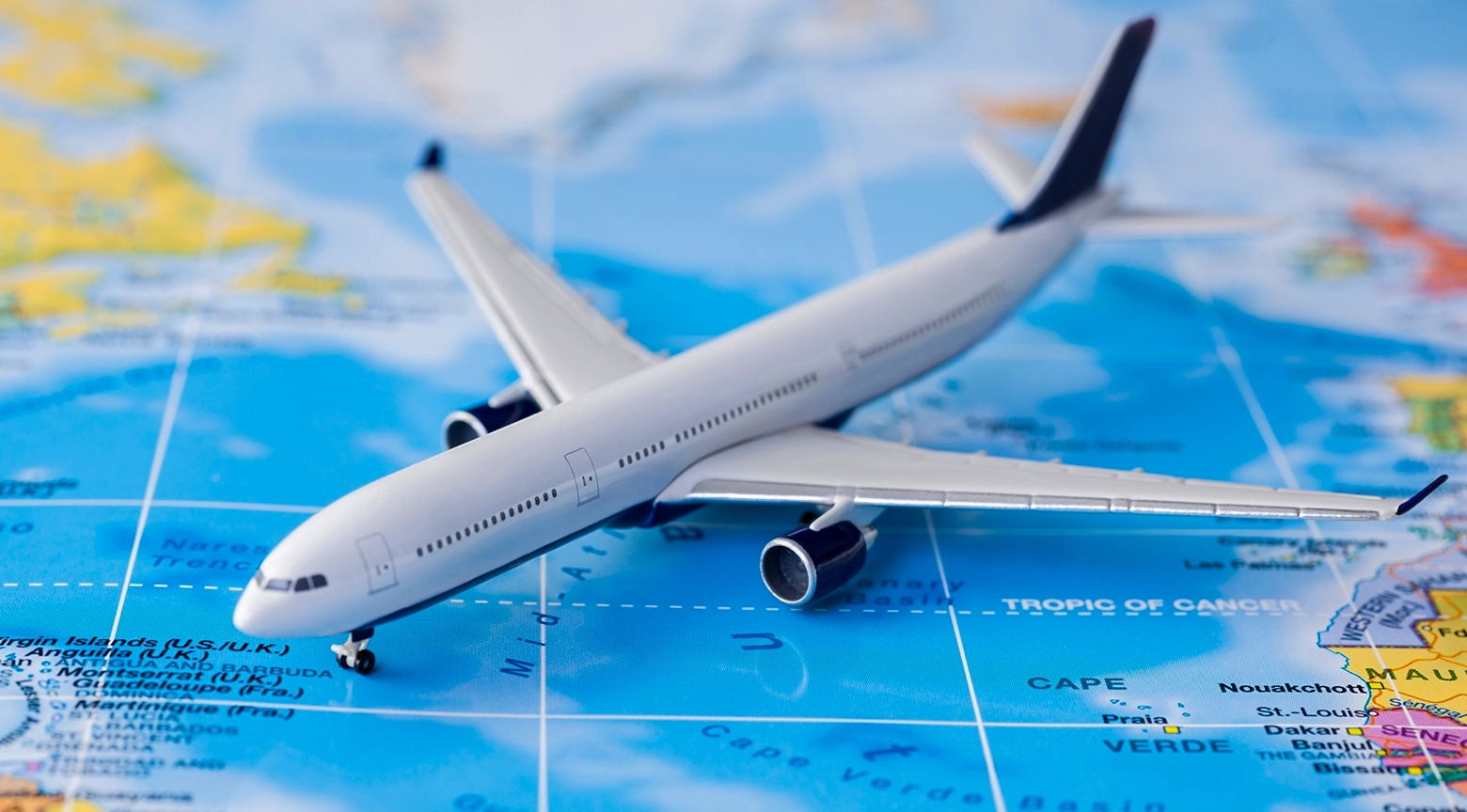 Maqueta de avión sobre un mapa mundial, representando las rutas aéreas y la conectividad internacional.