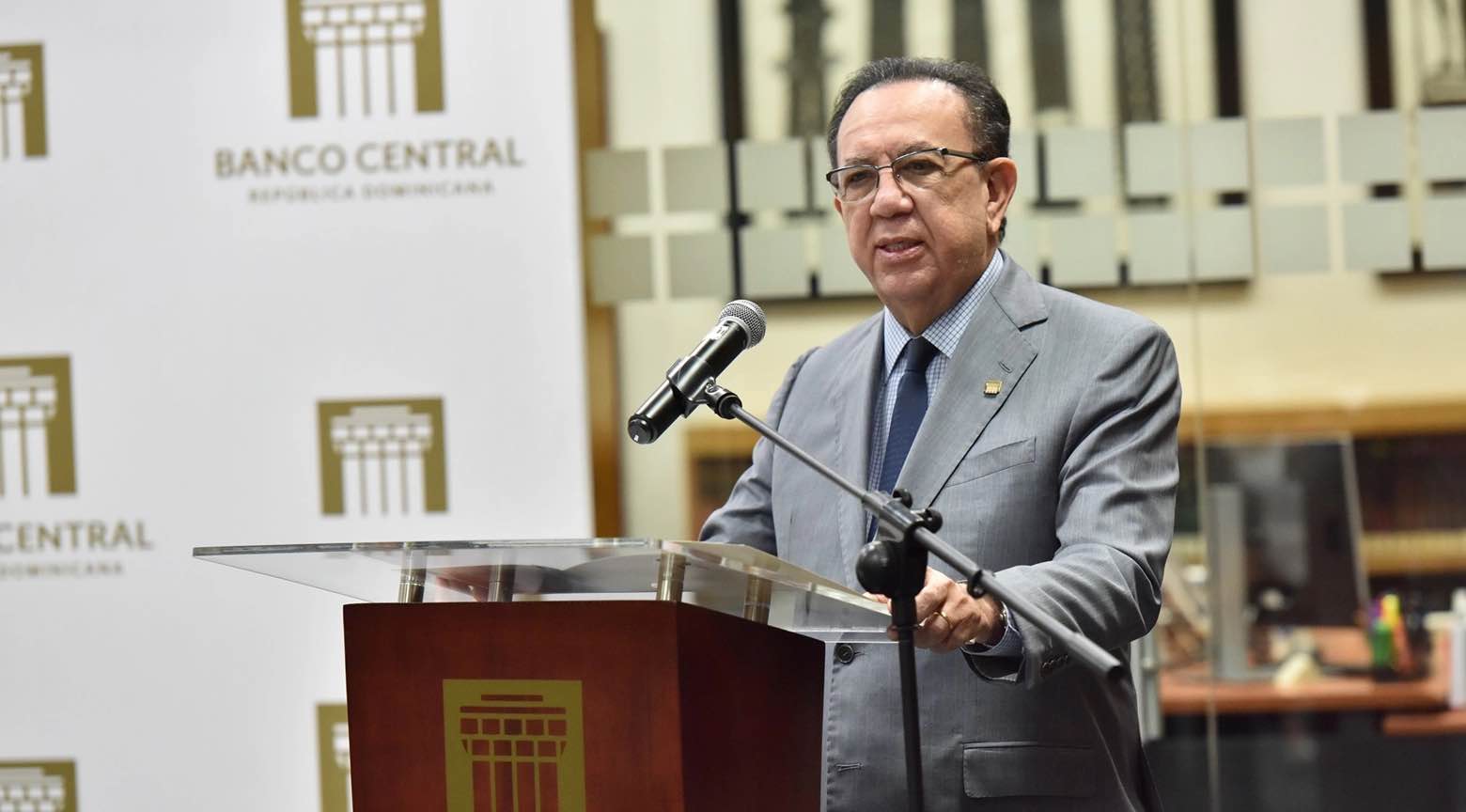 Gobernador del Banco Central de la República Dominicana hablando en un podio durante un acto institucional.