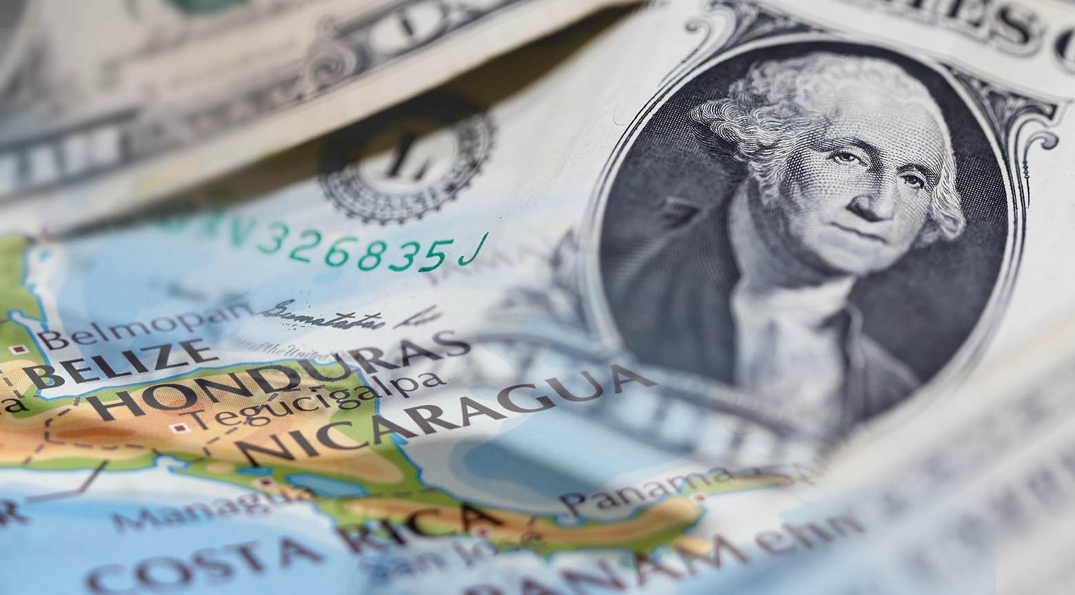 Billete de dólar estadounidense sobre un mapa de Centroamérica, mostrando países como Honduras, Nicaragua y Costa Rica.