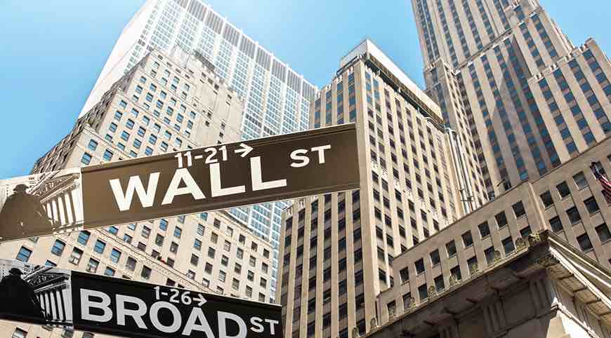 Señales de Wall Street y Broad Street entre rascacielos en el distrito financiero de Nueva York.