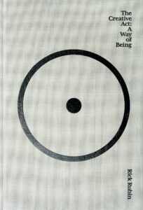 Portada del libro The Creative Act: A Way of Being de Rick Rubin, con un diseño minimalista que muestra un círculo negro incompleto y un punto central sobre fondo claro.