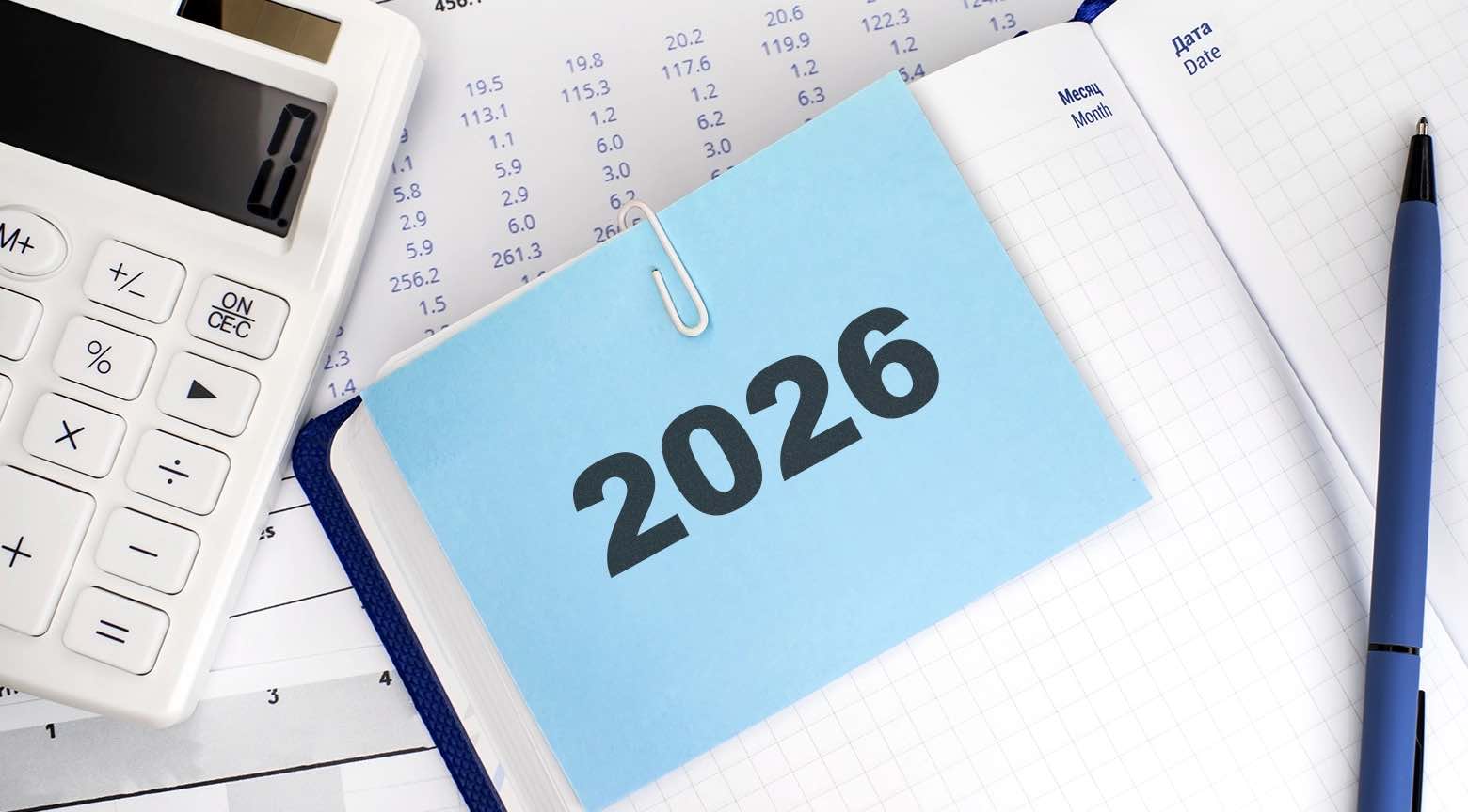 Agenda con el año 2026 sobre documentos financieros, calculadora y cuaderno, representando la planificación de presupuesto e inversiones personales.