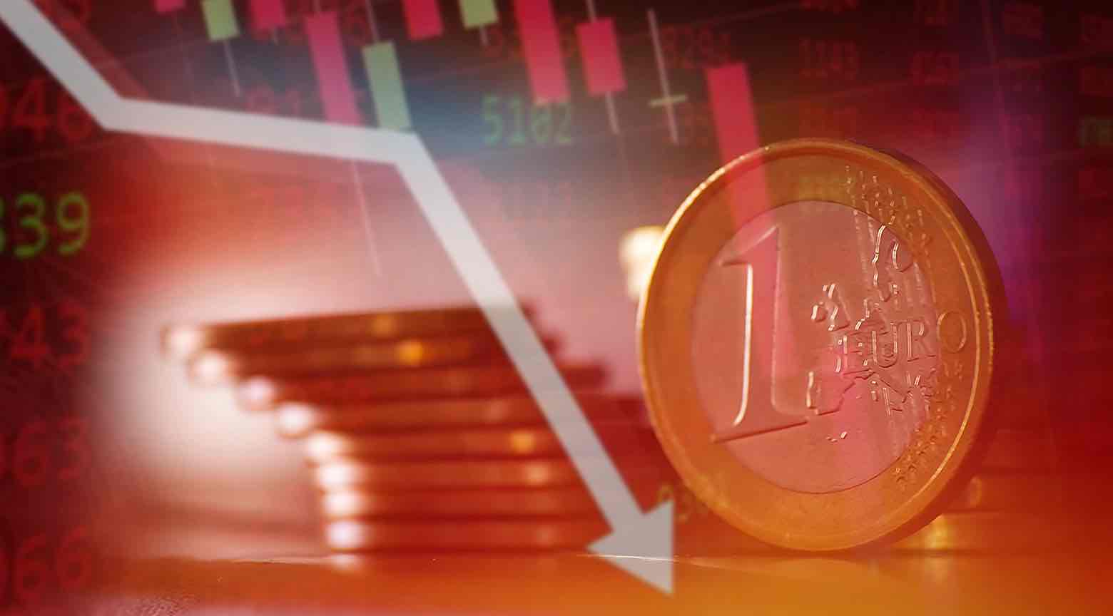 Moneda de un euro frente a un fondo bursátil en tonos rojos con una flecha descendente que simboliza caída en los mercados.