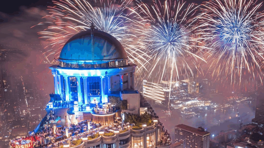 Fuegos artificiales iluminan el cielo nocturno sobre un edificio emblemático durante la celebración de Año Nuevo en una gran ciudad.