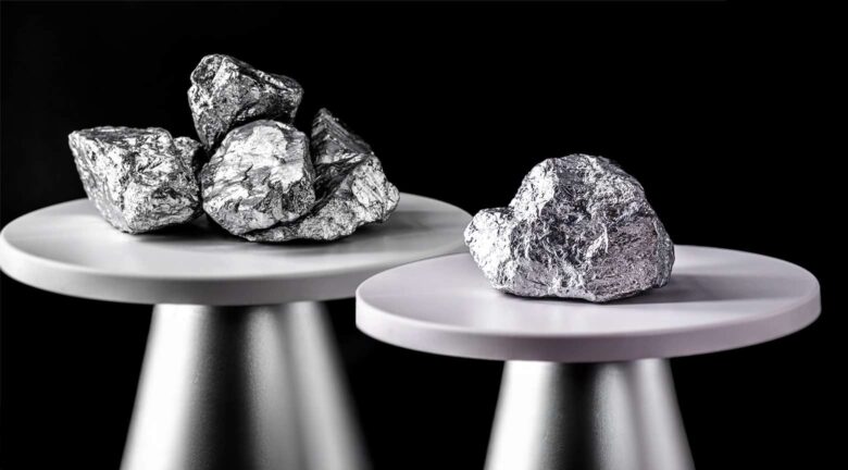 Lingotes y rocas de platino y paladio colocados sobre pedestales, representando el repunte de estos metales en los mercados globales.