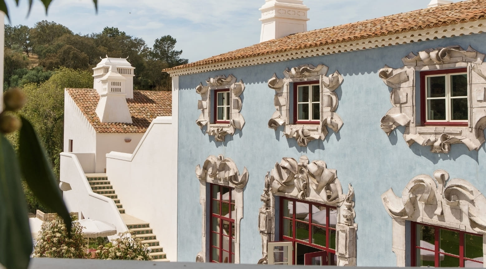 Vista exterior del Hotel Vermelho en Melides, Portugal, con arquitectura tradicional del Alentejo, fachadas restauradas y terrazas al aire libre integradas al entorno.