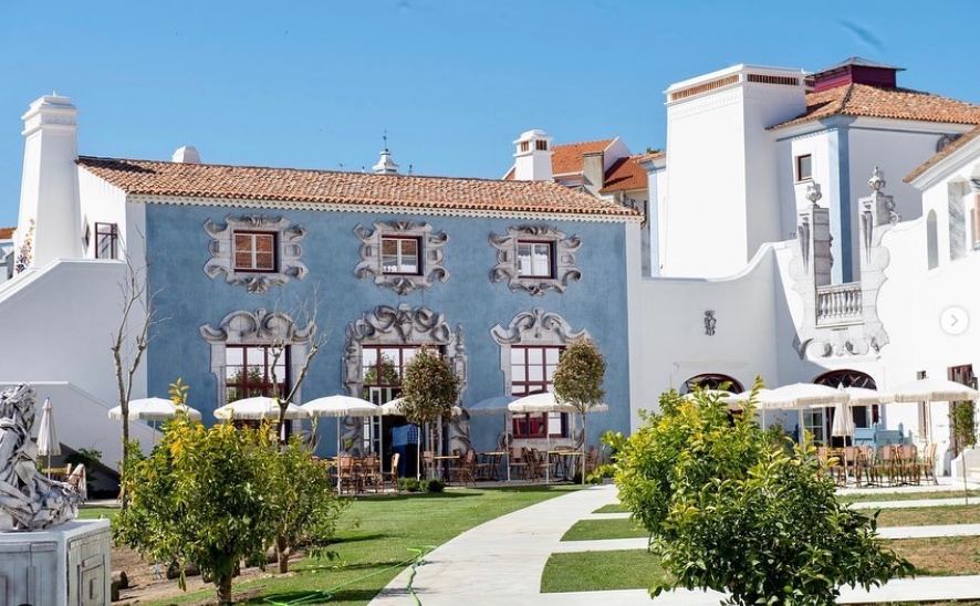 Vista exterior del Hotel Vermelho en Melides, Portugal, con arquitectura tradicional del Alentejo, fachadas restauradas y terrazas al aire libre integradas al entorno.