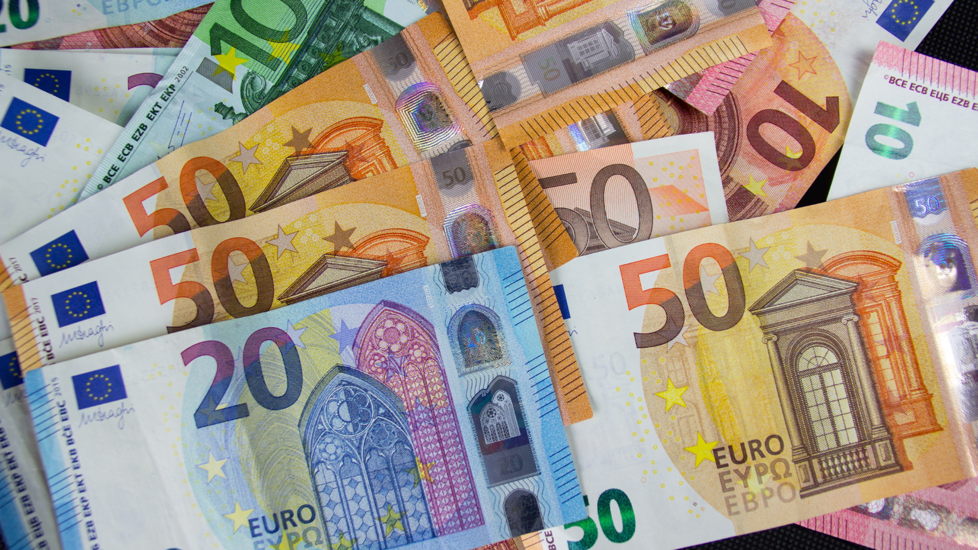 Billetes de euro de distintas denominaciones superpuestos, representando la moneda europea.