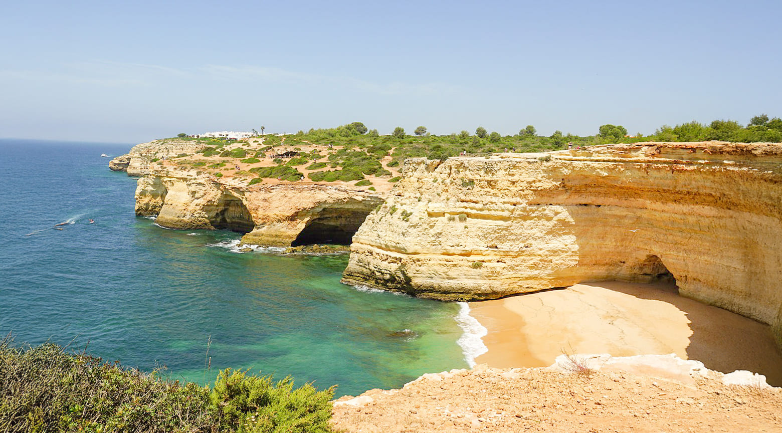 Acantilados dorados y cala de arena en la costa del Algarve, cerca de Benagil, Portugal.