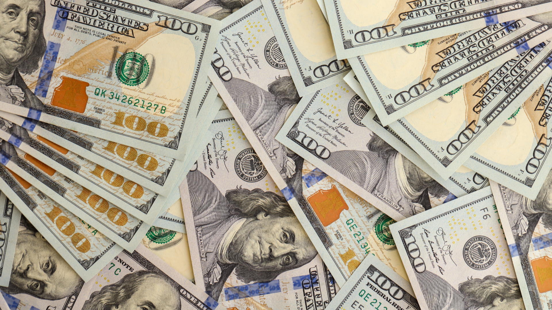 Billetes de 100 dólares estadounidenses superpuestos, vistos en primer plano.