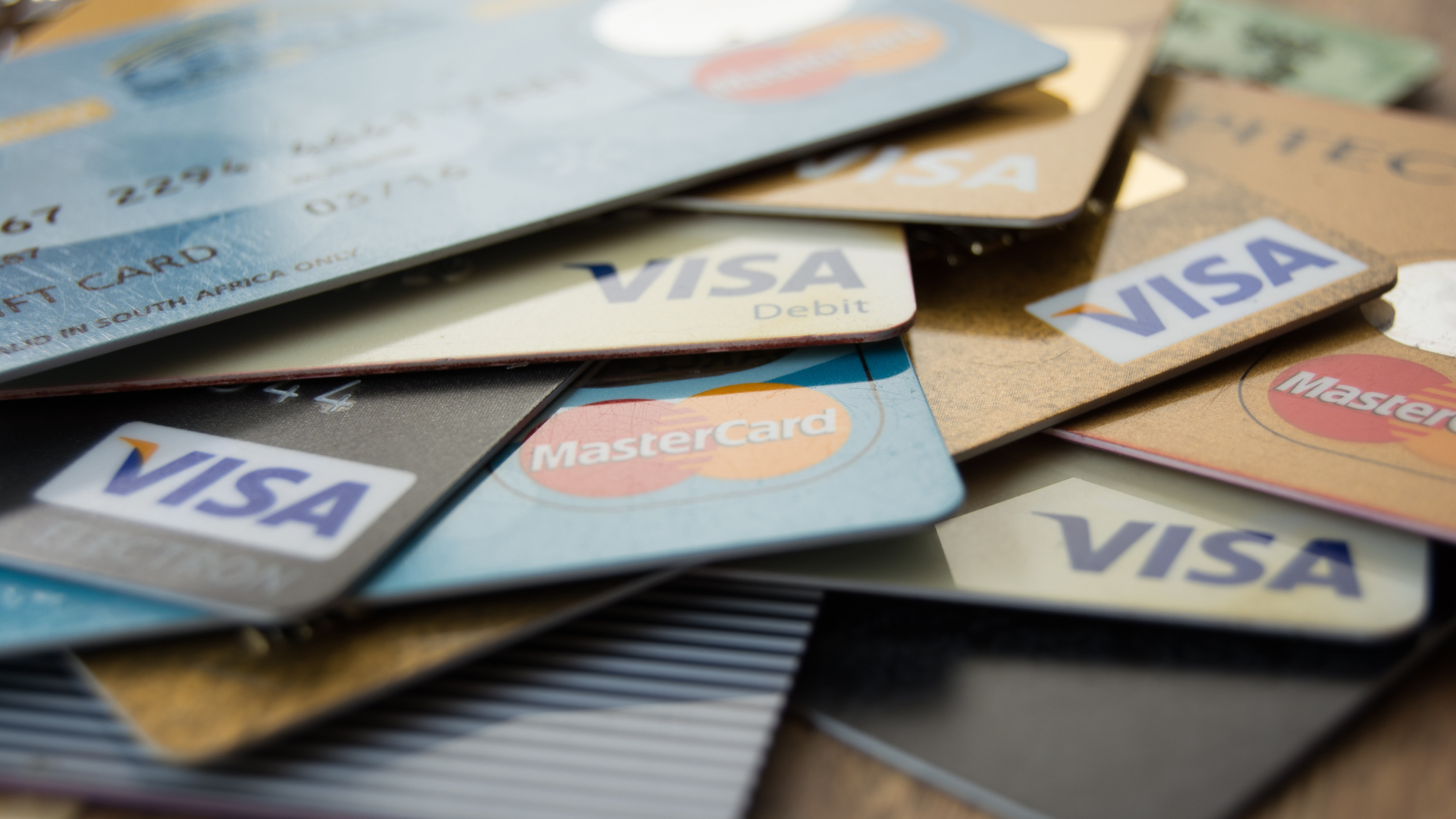 Varias tarjetas de crédito y débito de Visa y MasterCard apiladas.