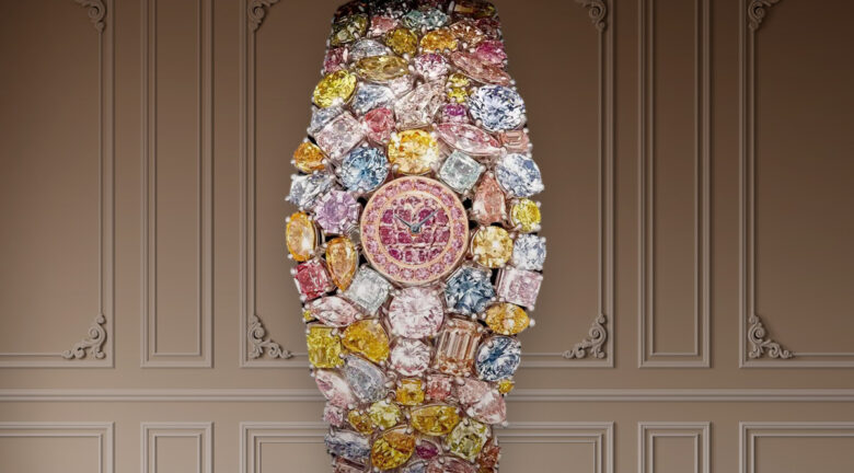 Reloj de lujo decorado con diamantes de colores, exhibido sobre un fondo elegante.