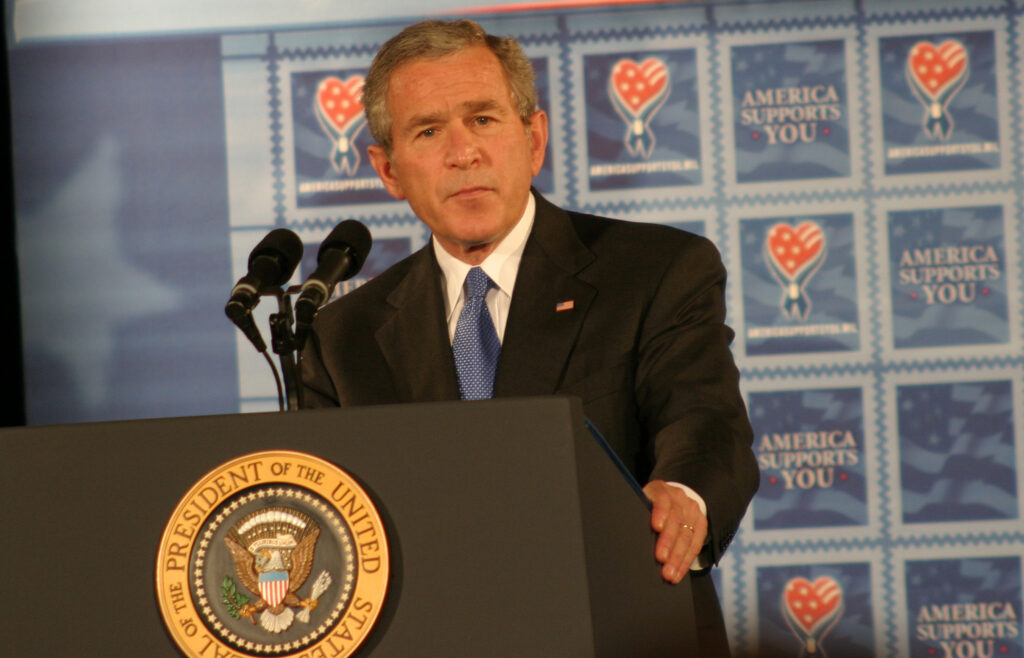George W. Bush hombre detrás de un podio con el escudo y sello del presidente de Estados Unidos