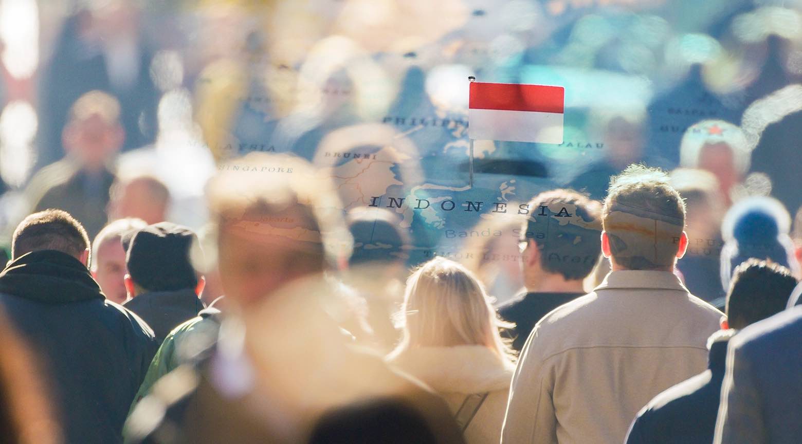 Multitud caminando en una ciudad con la bandera de Indonesia sobre un mapa de fondo.