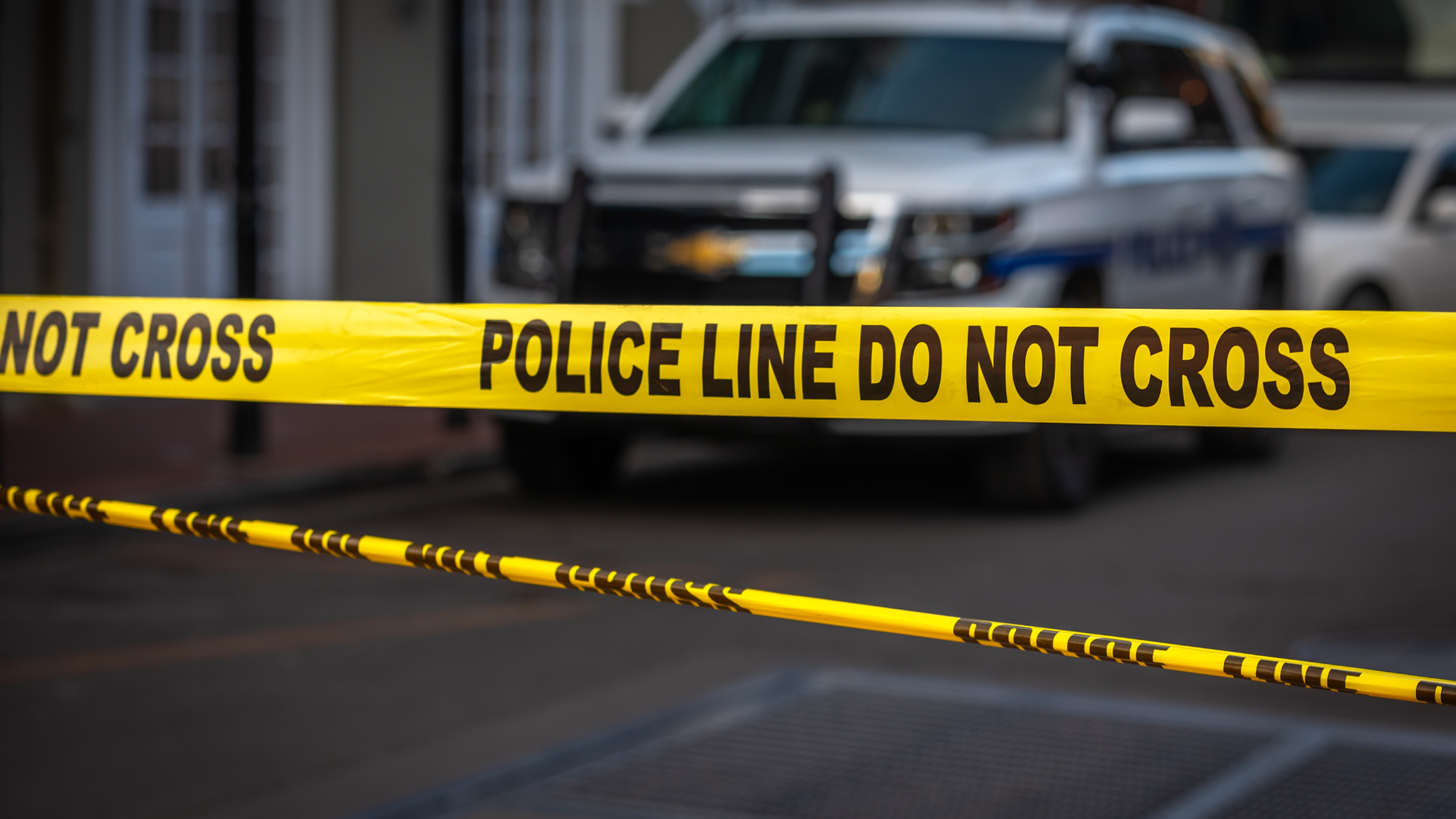 Cinta amarilla de “Prohibido el paso” en una calle de tierra acordonada por la policía.