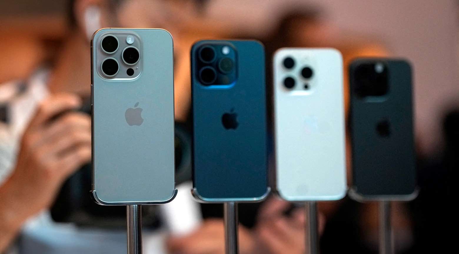 Varios modelos de iPhone exhibidos en fila sobre soportes durante un evento de presentación.