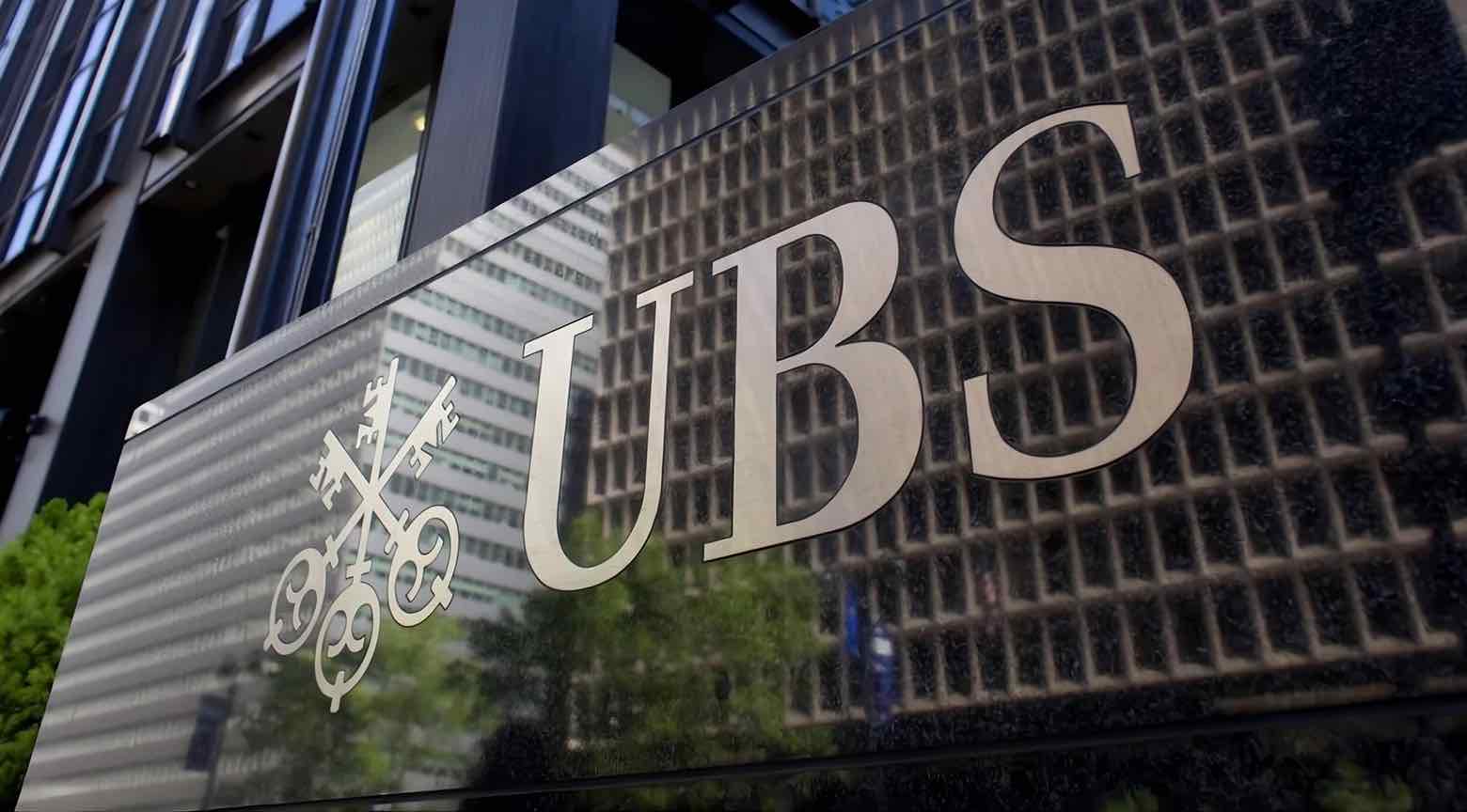 Logotipo de UBS en la fachada de un edificio en una ciudad moderna.