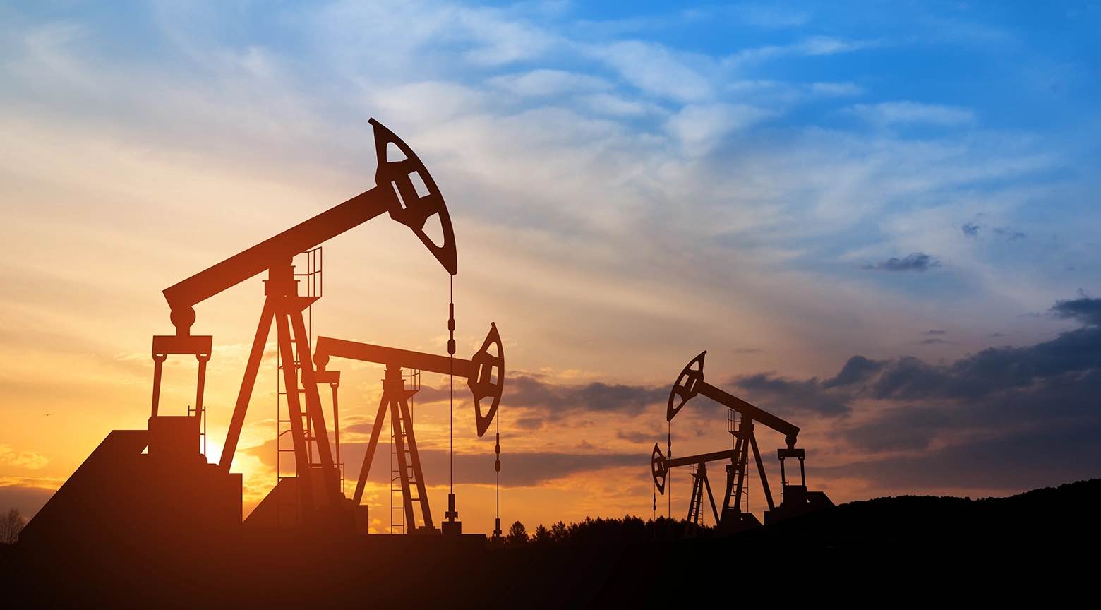 Bombas extractoras de petróleo operando al atardecer en un campo petrolero.