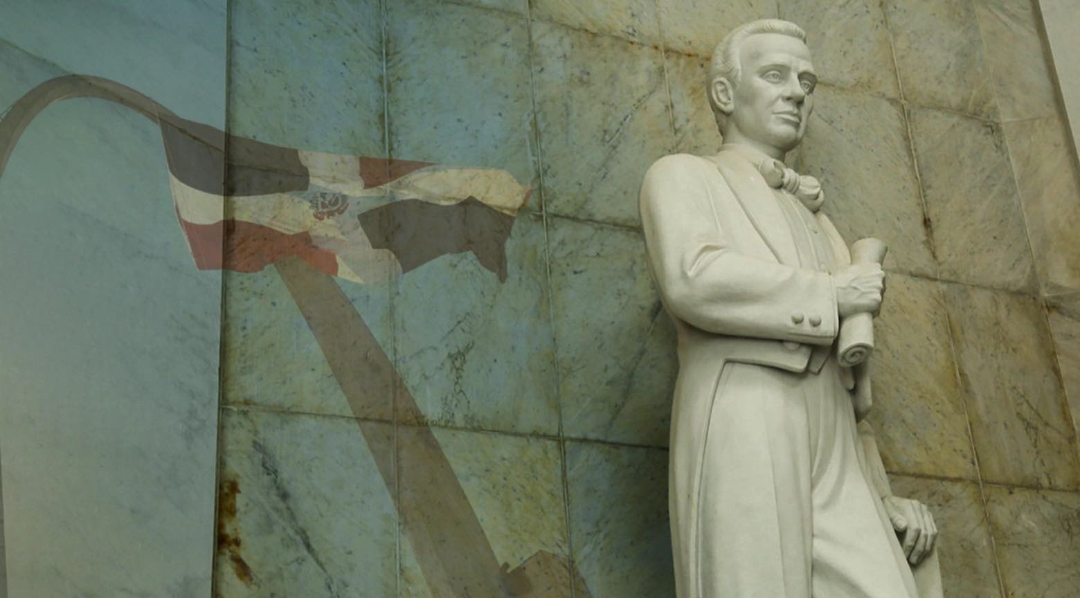 Estatua de Francisco del Rosario Sánchez junto a la bandera de la República Dominicana en un monumento conmemorativo.