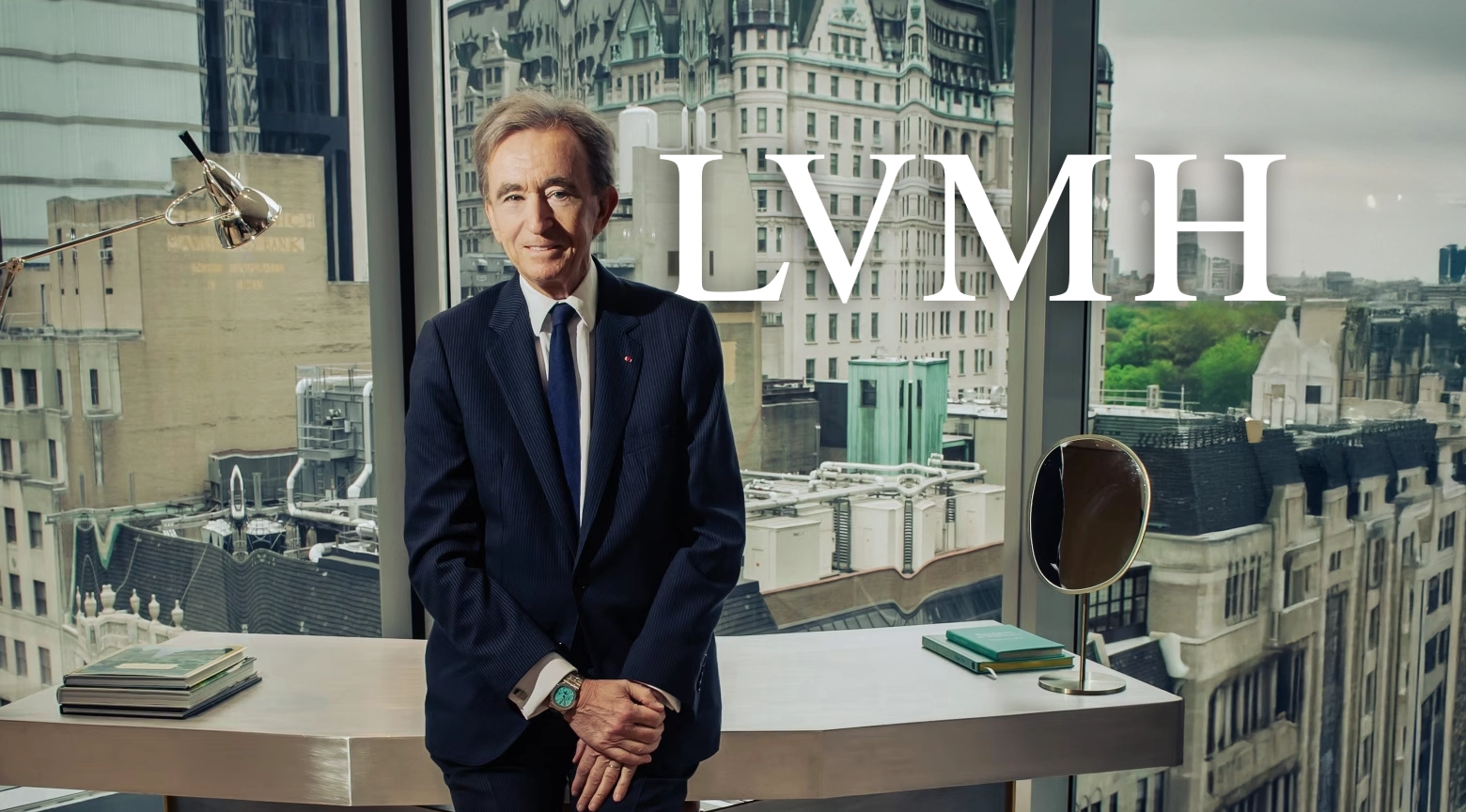Bernard Arnault, CEO de LVMH, posando frente a una ventana con vista panorámica de la ciudad, mientras el logo de LVMH aparece sobre la imagen.