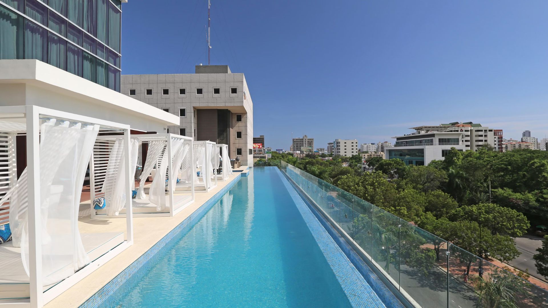 Piscina infinita en azotea con vista panorámica a la ciudad.