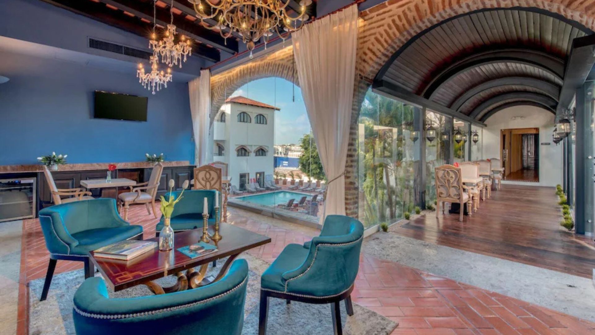 Salón interior de hotel con vista a piscina y decoración elegante.