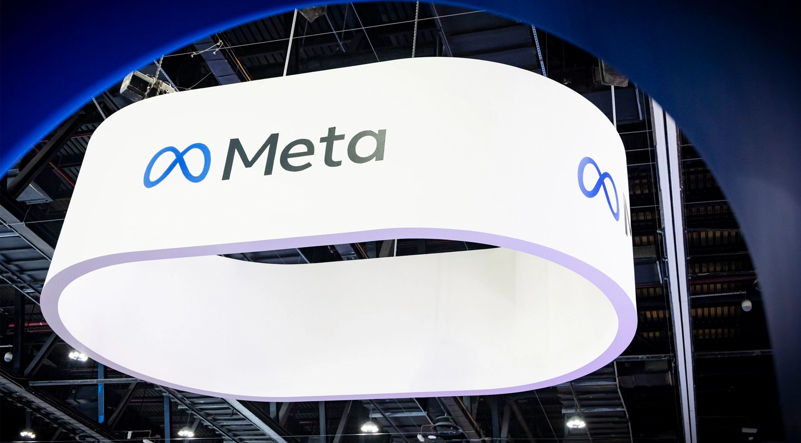 Logotipo de Meta, la empresa matriz de Facebook, exhibido en una gran estructura en un evento, con el símbolo del infinito y el nombre "Meta" en letras negras.