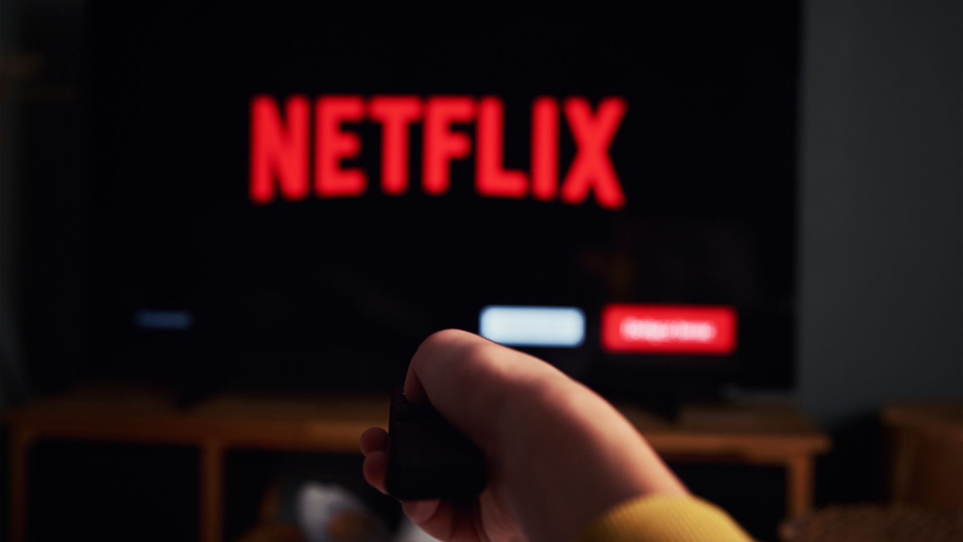 Un control remoto apuntando a una pantalla de televisión con el logotipo de Netflix en la parte superior.