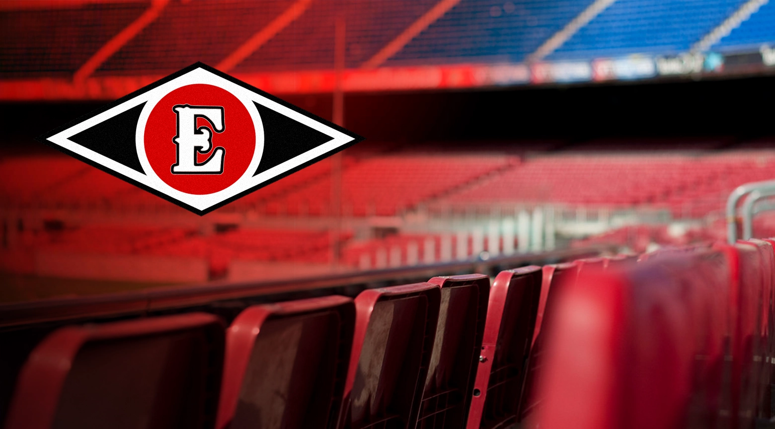 Interior del estadio con asientos rojos vacíos y el logo del equipo Escogido en primer plano.