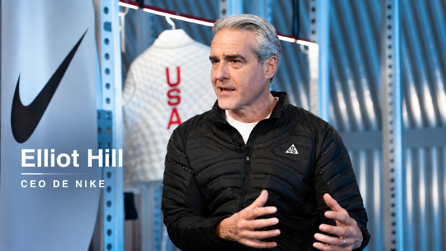 Elliott Hill, CEO de Nike, durante una entrevista en un espacio de la compañía con el logotipo de Nike al fondo.