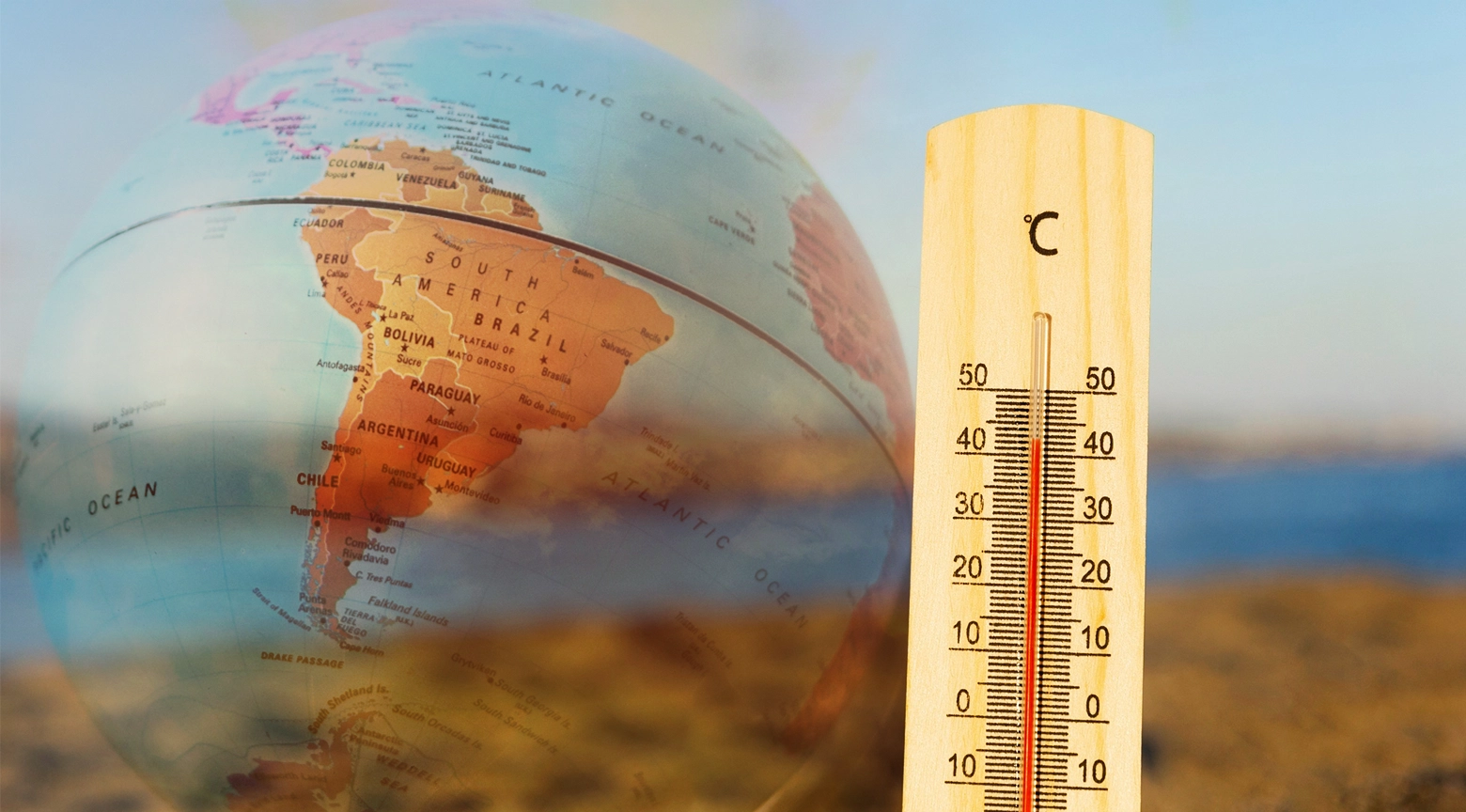 Globo terráqueo con un mapa de América del Sur junto a un termómetro que marca temperaturas elevadas, representando el impacto del fenómeno climático El Niño en la región.
