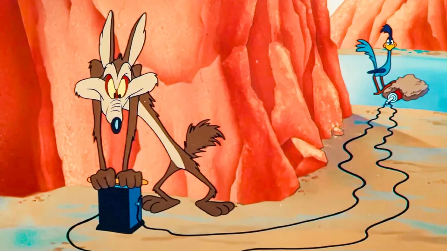 Wile E. Coyote manipula un artefacto de Acme mientras el Correcaminos lo observa a la distancia en el desierto.