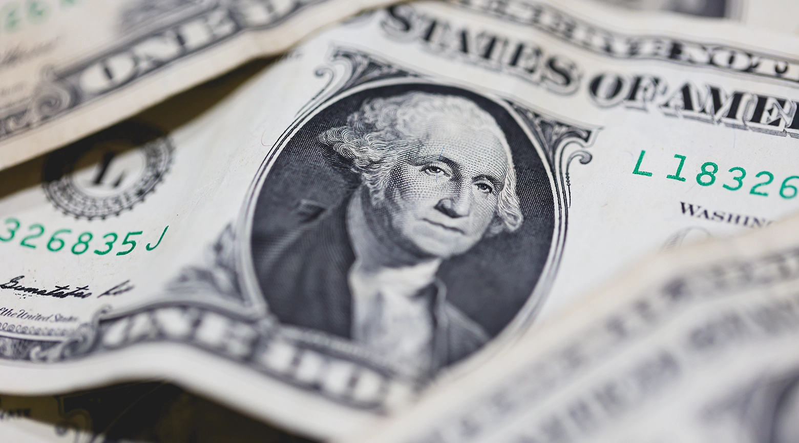 Primer plano de varios billetes de un dólar estadounidense superpuestos, con el retrato de George Washington en el centro. La imagen representa la moneda estadounidense y su importancia en las operaciones financieras y cambiarias.