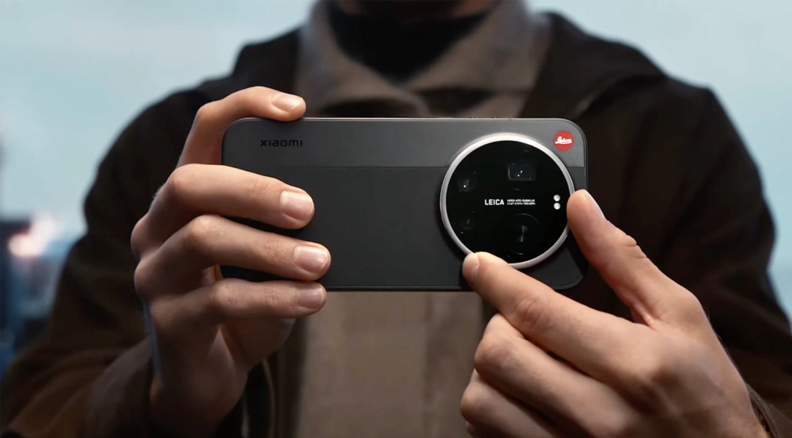 Persona sostiene horizontalmente un teléfono inteligente Xiaomi de color negro, equipado con un gran módulo circular de cámaras desarrollado en colaboración con Leica. La imagen destaca el diseño del dispositivo y su sistema fotográfico.